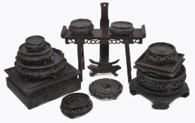 A quantity of Chinese hardwood stands, of circular and rectangular form, including some plate stands