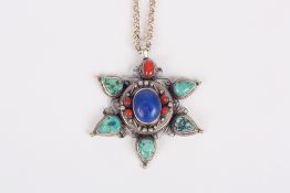 A star shaped coral, turquoise, lapiz lazuli and white metal pendant the outer section of the