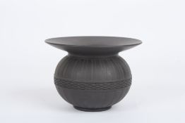 A Wedgwood black basalt spittoon, with broad flared neck and ribbed globular body with basket