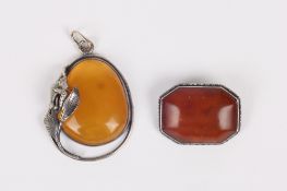 An amber brooch and an amber pendant, the first of octagonal form and mounted in a white metal frame