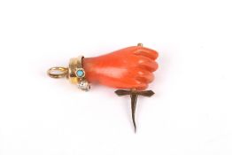 A Victorian carved coral charm, formed as a hand holding a dagger, with diamond and turquoise
