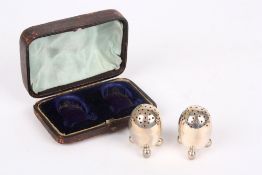 A Victorian pair of miniature silver pepperettes, hallmarked London 1869, raised on three ball feet,