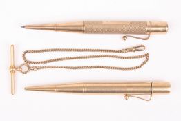 Two 9ct gold propelling pencils and a gold Albert chain, one pencil with engine turned decoration