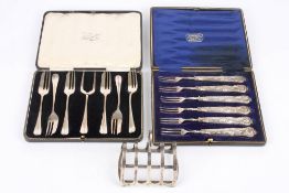 A George V silver toast rack, hallmarked Chester 1912, together with a cased set of cake forks and a