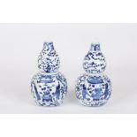A pair of Chinese blue and white double gourd vases and covers, late 19th / early 20th century,