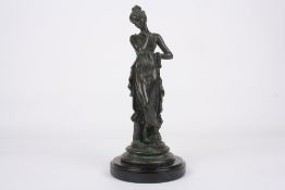 A French spelter model of a young maiden, in classical pose and flowing robes, supported on a