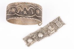 Two white metal bangles, one a cast solid white metal bangle, the other a filigree silver bracelet