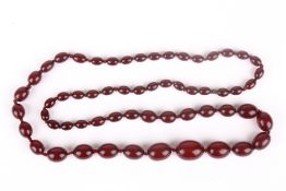 A Cherry Amber coloured graduated bead necklace, the beads of ovoid form. 80cm long . Good