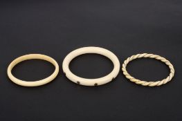 A Victorian Ivory and gold slave bangle, together with two other late 19th/early 20th century
