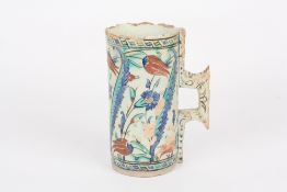 An Iznik pottery tankard, Turkey, 17th century of cylindrical form with angular handle, the body