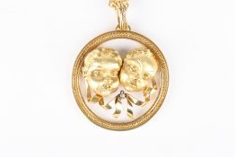 An 18ct yellow gold and diamond pendant, formed as two cherub masks with a diamond set ribbon in a