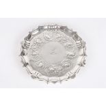 A Victorian silver salver, hallmarked London, of fluted form with repoussé decoration of scrolls,