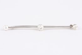 A triple diamond bar brooch, set with central diamond weighing approx. 0.43cts, with smaller