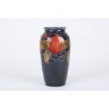 A William Moorcroft Pomegranate vase, decorated with leaves, berries and pomegranates on a blue