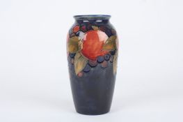 A William Moorcroft Pomegranate vase, decorated with leaves, berries and pomegranates on a blue