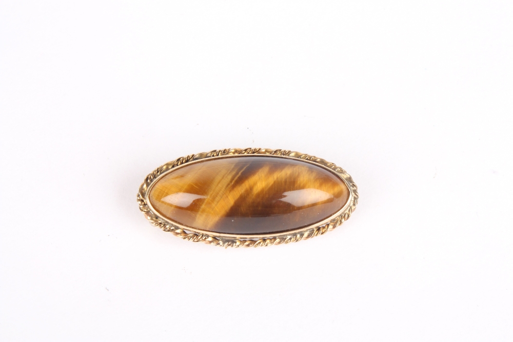 A 9ct gold oval tigers eye brooch, with rope-twist mount, stamped 9ct. 3.75 wide . Good condition.