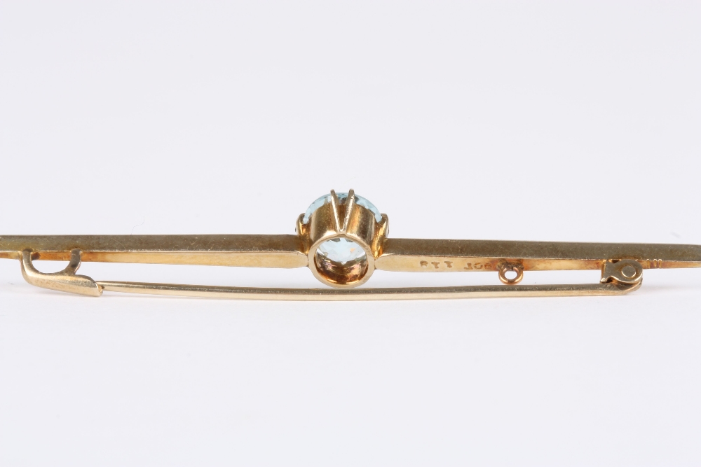 A 9ct gold and aquamarine bar brooch, with an oval claw-set aquamarine on a tapering bar, stamped - Image 2 of 2