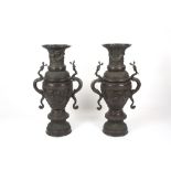 A pair of 20th century floor standing Japanese bronze vases, the urn shaped vases heavily