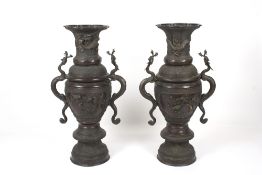 A pair of 20th century floor standing Japanese bronze vases, the urn shaped vases heavily