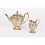 A Victorian Adam design silver teapot and matching cream jug, hallmarked London 1880, the body