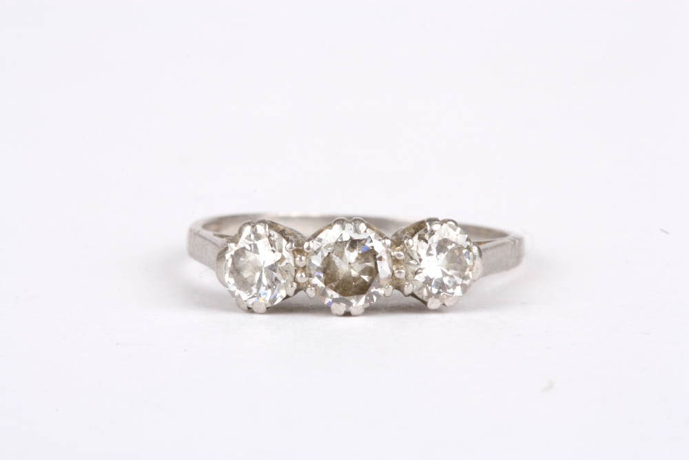 A platinum and diamond three stone ring, with double claw setting and plain shank. Size M ½ . No