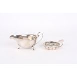 An Asprey silver sauce boat, hallmarked Birmingham 1925, together with a white metal wine taster,