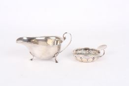 An Asprey silver sauce boat, hallmarked Birmingham 1925, together with a white metal wine taster,