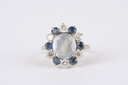 An Art Deco Sapphire and diamond cluster ring, set with central pale blue sapphire surrounded by