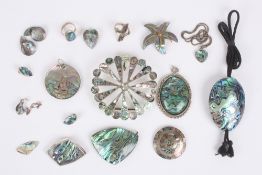 A collection of abalone costume jewellery, including several pendants one with a mounted sailing