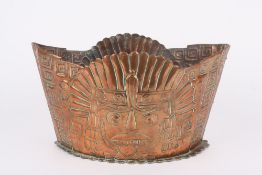An Arts & Crafts embossed copper boat shaped jardiniere, circa 1890, with Aztec inspired embossed
