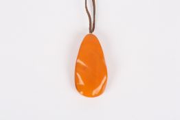 A large Baltic amber pendant, early 20th century the butterscotch coloured pendant of elongated