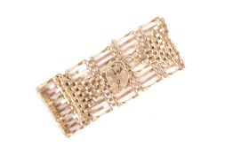 A 9ct gold ten bar gate bracelet, on padlock clasp with safety chain, 18.6g .