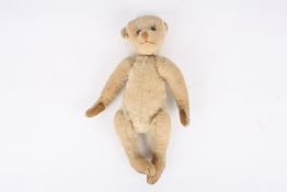 An early 20th century bear, possibly Steiff, with golden plush, elongated limbs, tan stitched