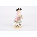 A 19th century Meissen porcelain figure of a young boy, holding a staff and wearing a colourful