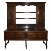 An 18th century oak dresserthe top with open plate rack flanked either side with a panelled door