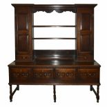 An 18th century oak dresser
the top with open plate rack flanked either side with a panelled door