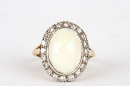 An 18ct gold, diamond and opal ringthe large oval opal surrounded by small diamonds and set in an