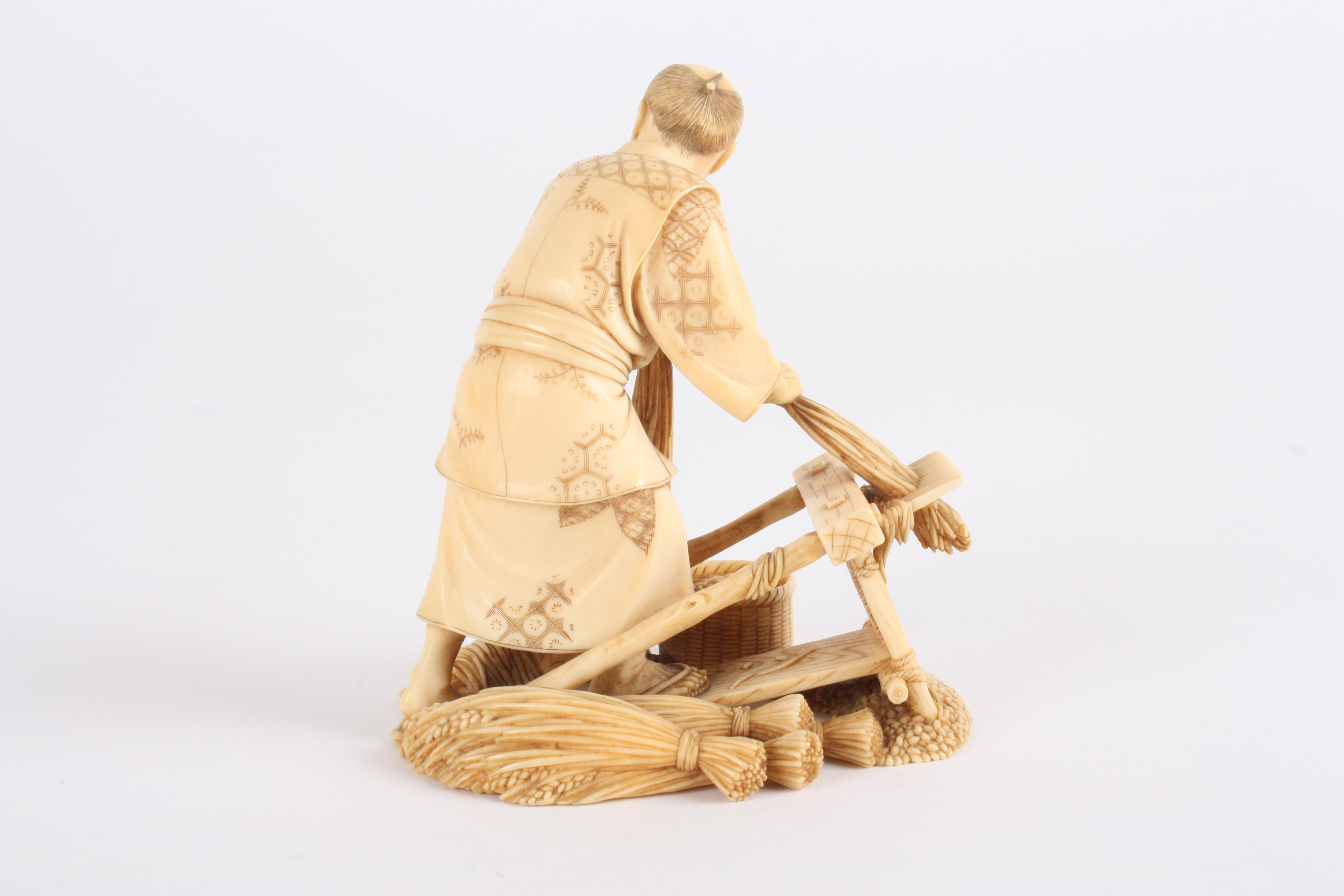 A Japanese finely carved ivory figure of a man
stood threshing corn using a foot operated machine, - Image 2 of 5