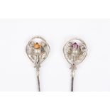 Two silver hat pins
both hallmarked Birmingham 1909, terminating in thistle decoration with coloured
