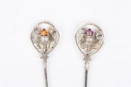 Two silver hat pinsboth hallmarked Birmingham 1909, terminating in thistle decoration with coloured