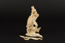 A Japanese ivory figure of a fish and a man the large carved fish having jumped from the coral