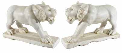 A pair of decorative white marble lionsrealistically modelled, in standing poses, on marble bases