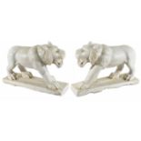 A pair of decorative white marble lions
realistically modelled, in standing poses, on marble bases