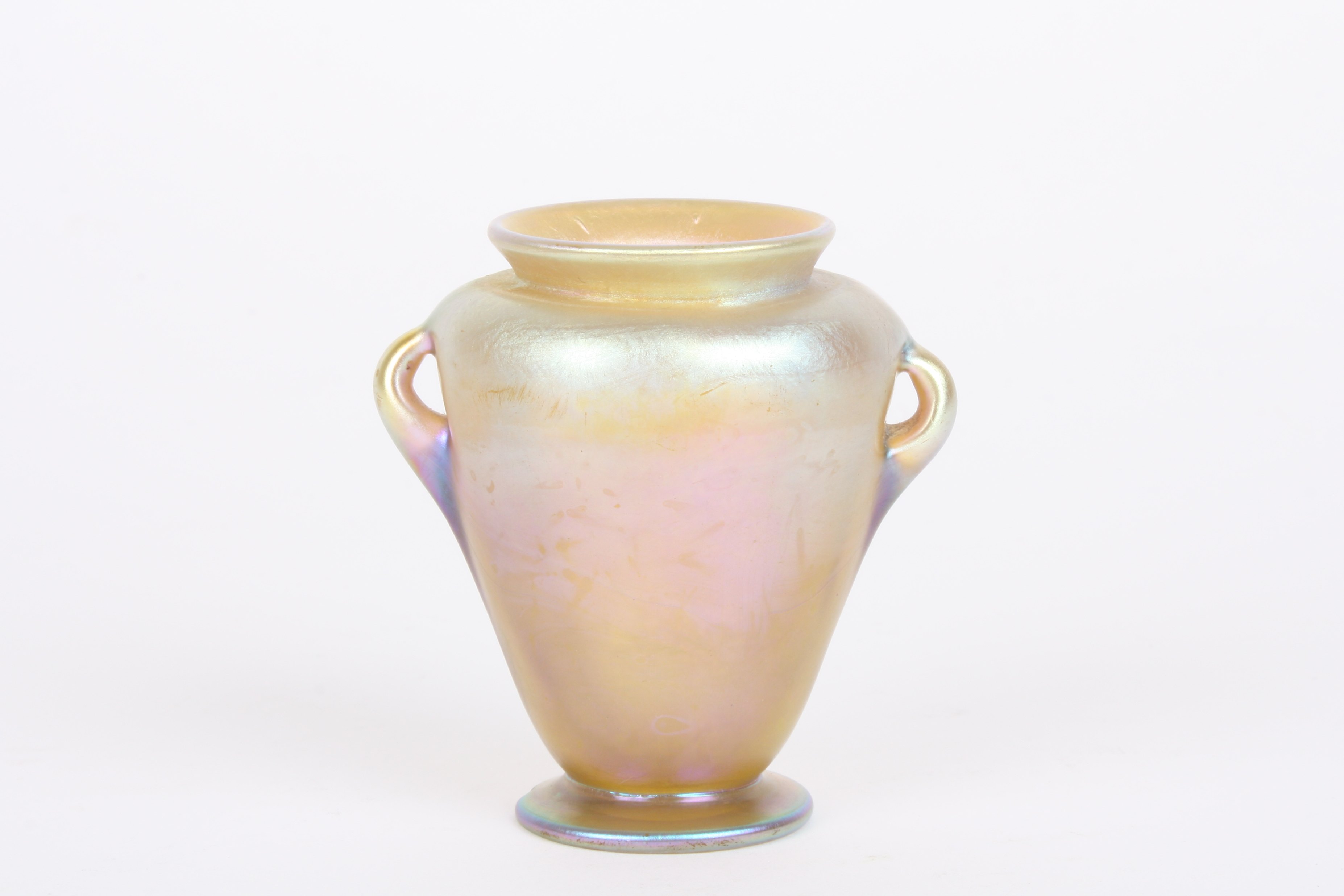A Louis Comfort Tiffany Favrile iridescent glass vase
of urn shaped form with small loop handles,