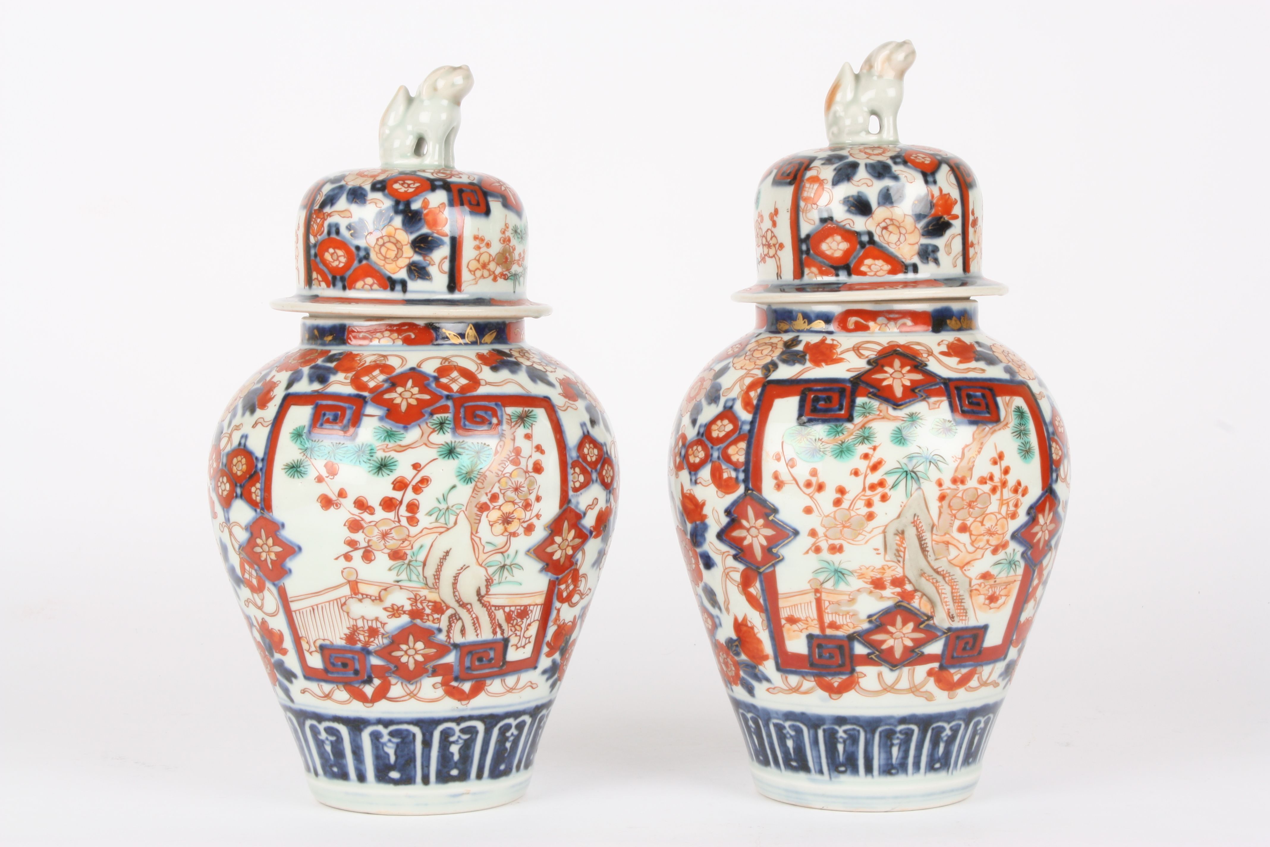 A pair of late 19th century Japanese Imari vases and covers
the lids crested with dogs of foe, the