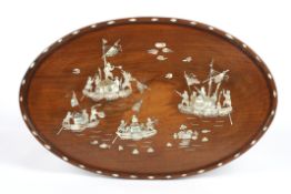 An oval wooden panelinlaid with mother-of-pearl depicting Oriental figures on boats fighting amidst