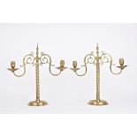 A large pair of brass candelabra, each with twin scrolled arms and circular sconces, supported on