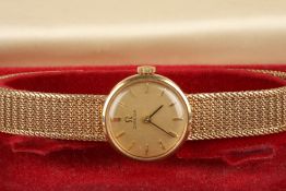 A 9ct gold ladies Omega wrist watchthe gilt dial with baton numerals, and a woven gold strap, in an