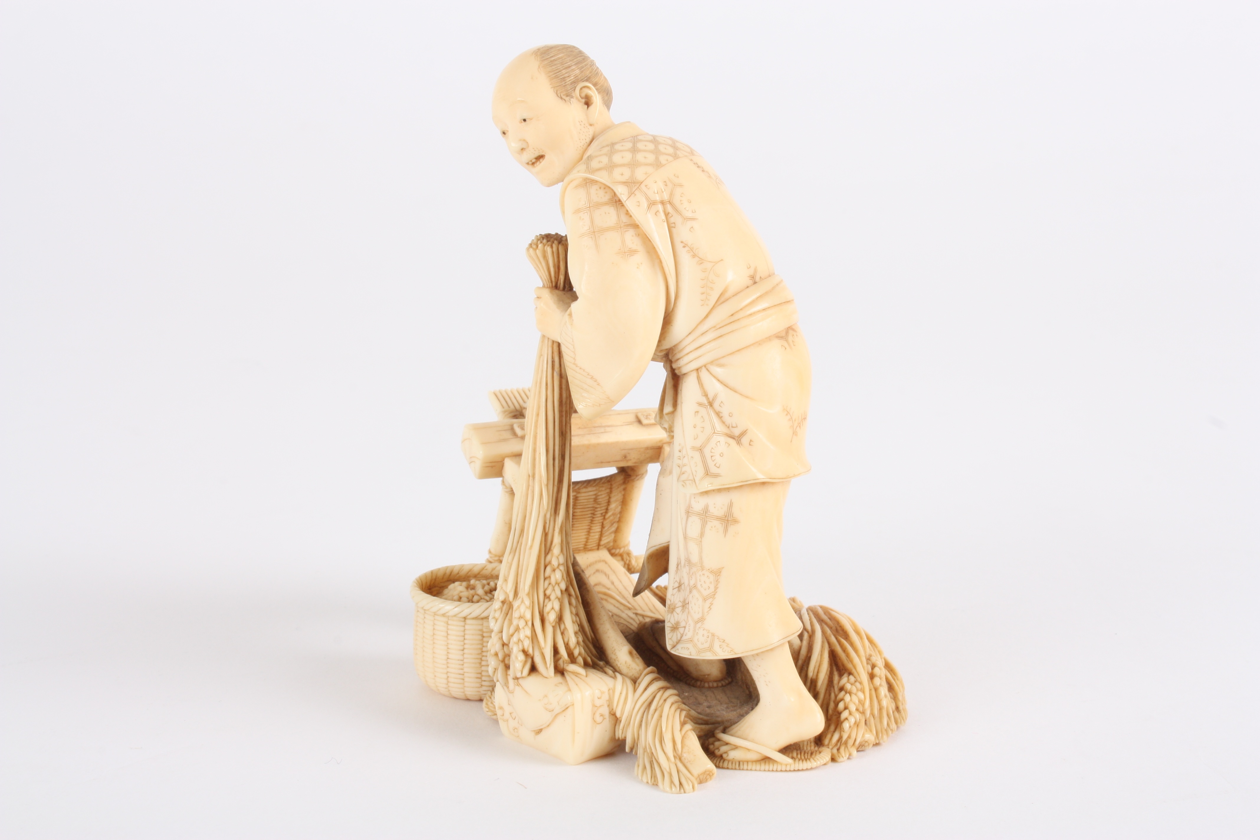 A Japanese finely carved ivory figure of a man
stood threshing corn using a foot operated machine, - Image 4 of 5