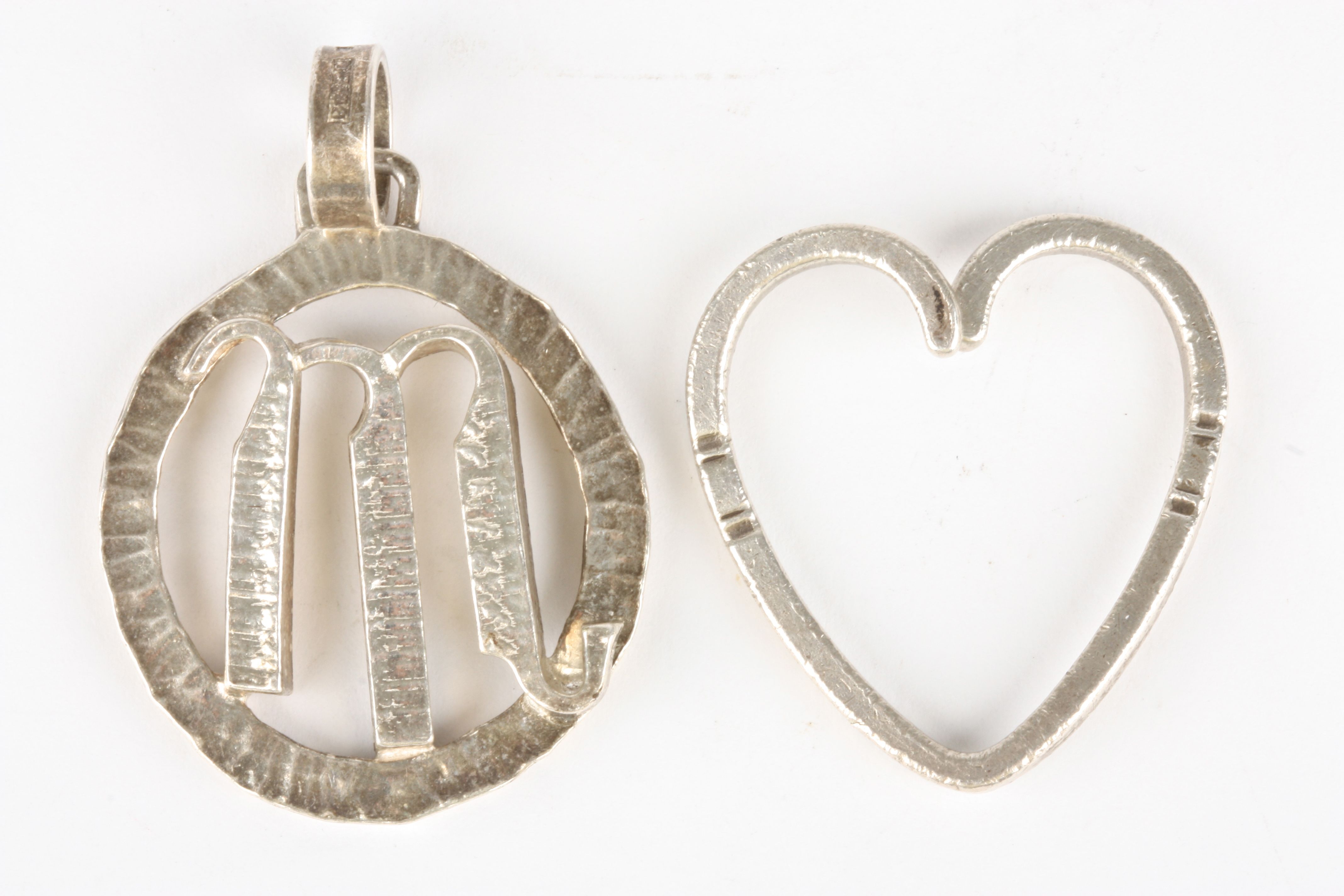 A Georg Jensen silver heart shaped pendant
together with another silver pendant with applied Scorpio